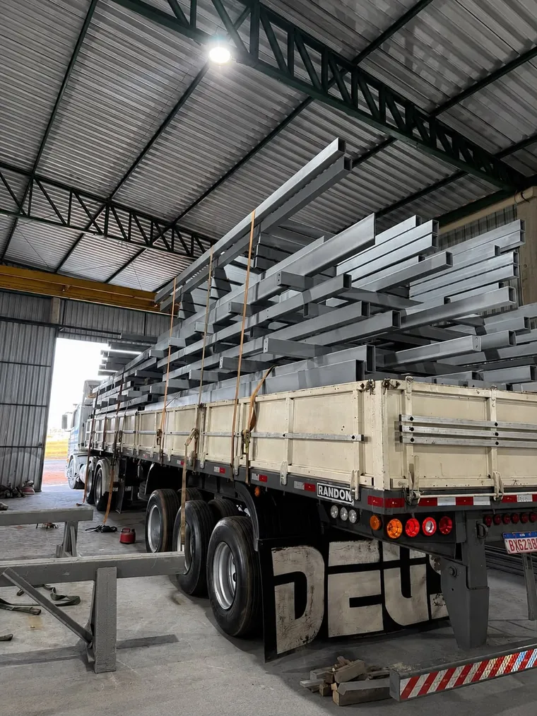 Perfis metálicos com pintura líquida industrial carregados para expedição